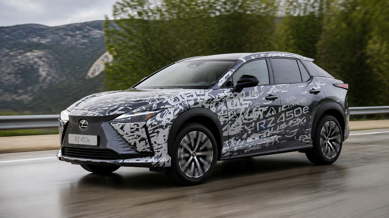 Carro elétrico Lexus RZ 450e em teste com camuflagem cinza e preta em estrada molhada e paisagem montanhosa.