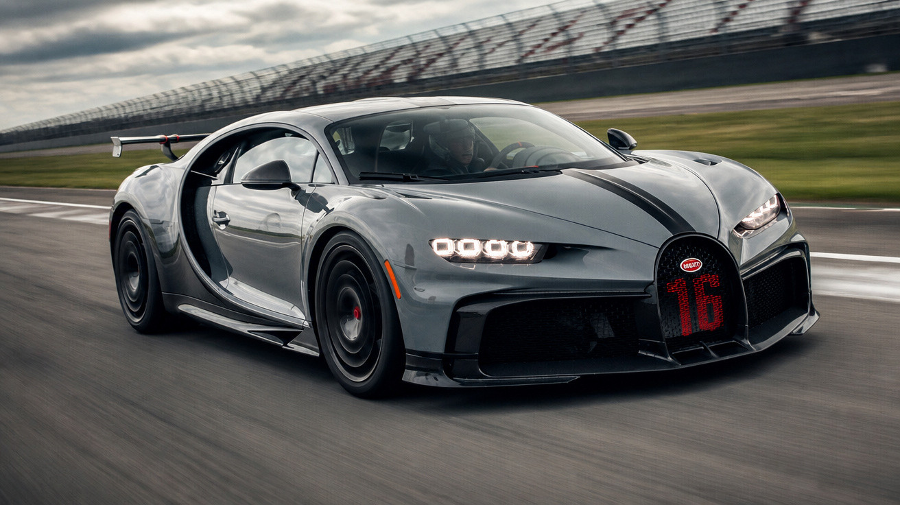Carro desportivo Bugatti Chiron cinzento a alta velocidade numa pista de corridas.