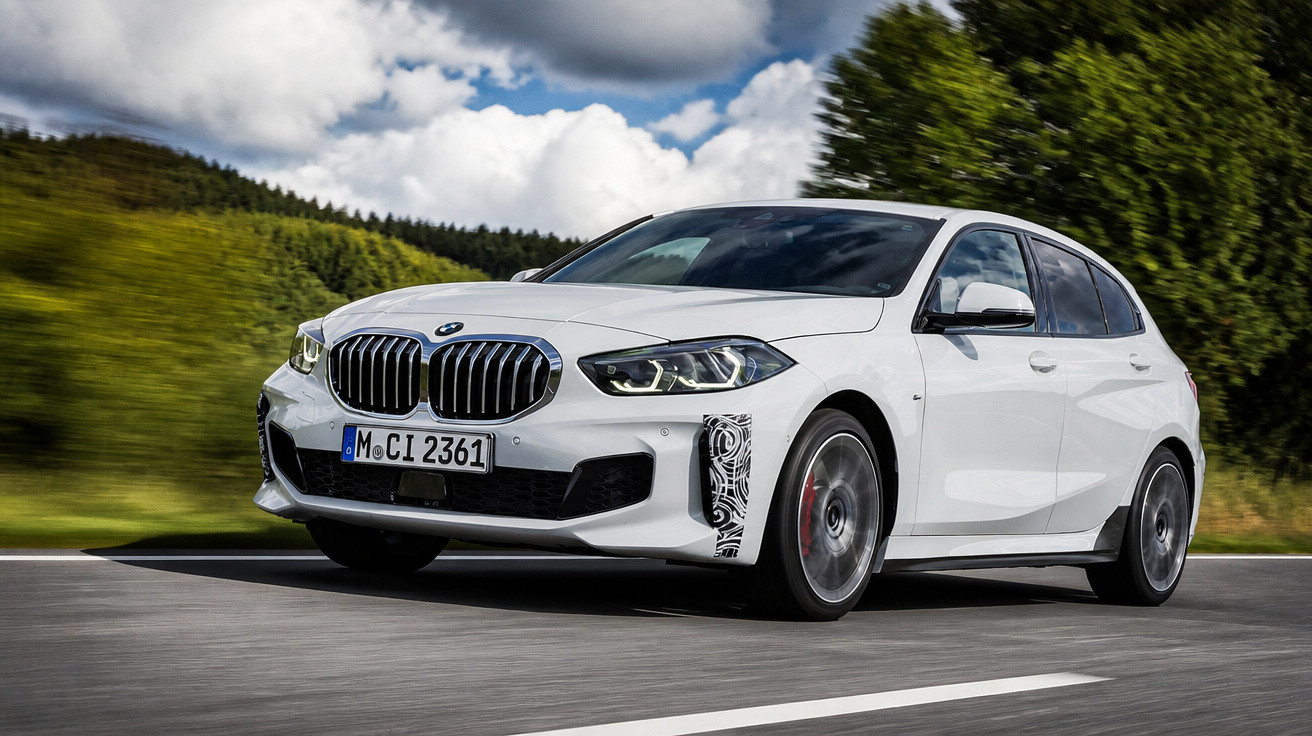 Carro BMW branco em movimento numa estrada rodeada de vegetação sob céu parcialmente nublado.