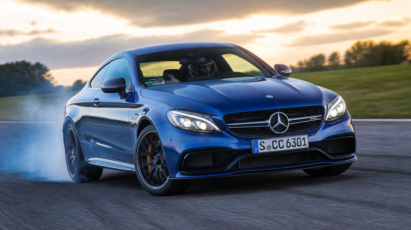 Carro desportivo Mercedes-Benz azul a derrapar numa pista ao pôr do sol.