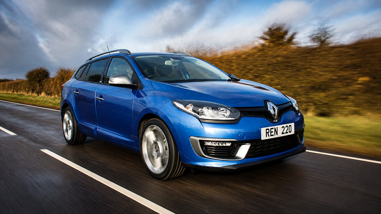 Carro azul Renault a circular numa estrada molhada com céu nublado e árvores ao fundo.